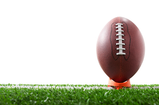 American Football Kick Off, A low angle of a football sitting on a tee over a yard line against a white background
