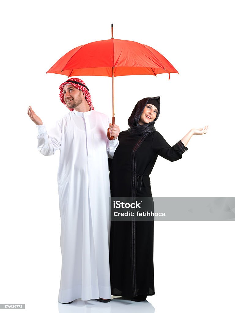 Red Umbrella and Arabian Young Couple Arabian couple holding red umbrella on a white background. 25-29 Years Stock Photo
