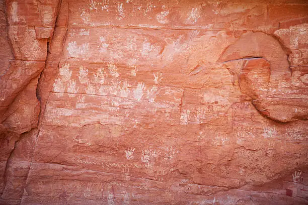 Wall of hand print petroglyphs at Many Hands Ruins in Mystery Valley part of Monument Valley in Arizona, USA.