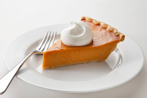 istock Slice of pumpkin pie and whipped cream on a white plate 174940816