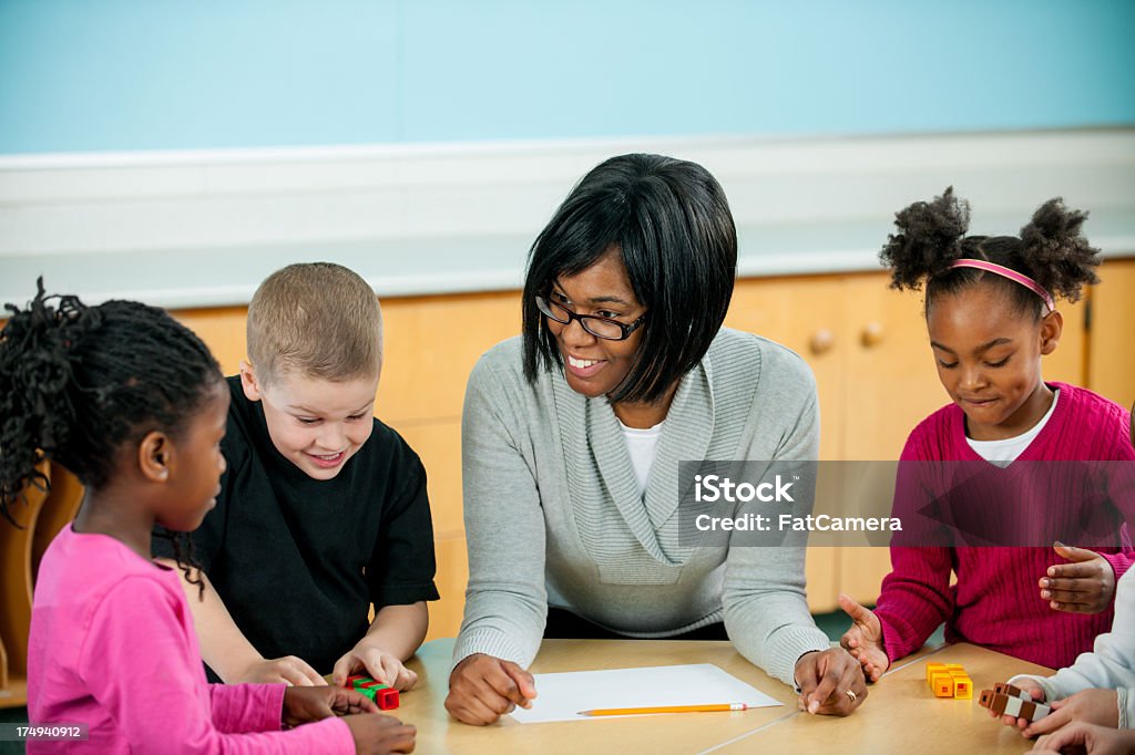 Classroom First graders in a classroom with teacher. Multiracial Group Stock Photo