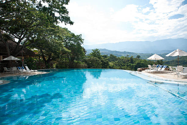 istock luxury pool with white umbrellas against lush vegetation 174941109