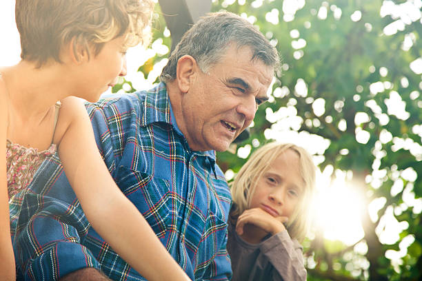 istock Happy senior farmer talks with kids 174941119