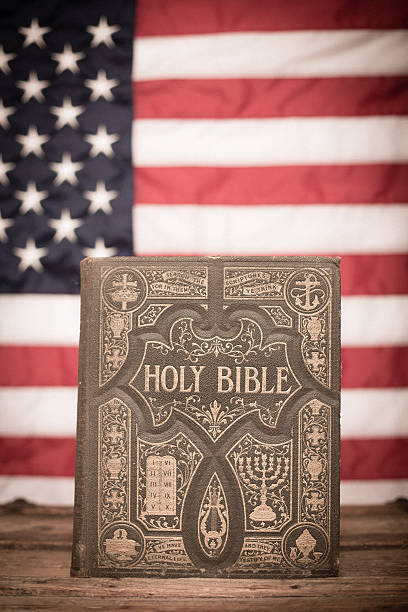 antica sacra bibbia, ornato con sfondo bandiera americana - bible american flag flag old fashioned foto e immagini stock