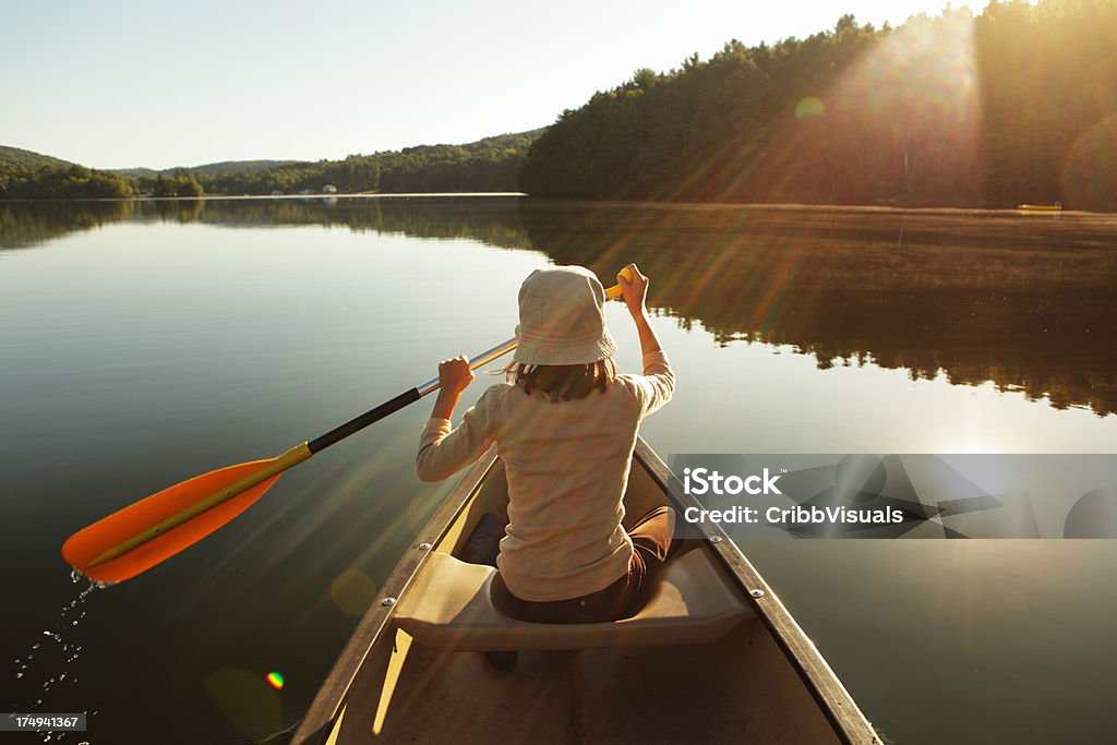 All'aperto ragazza pagaiare in canoa sul lago in alba nebbiosa brillante - Foto stock royalty-free di Canoa