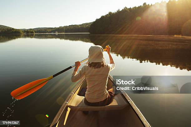 Allaperto Ragazza Pagaiare In Canoa Sul Lago In Alba Nebbiosa Brillante - Fotografie stock e altre immagini di Canoa