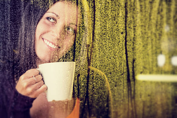 istock romantic young girl looks at  rain through the window 174941508