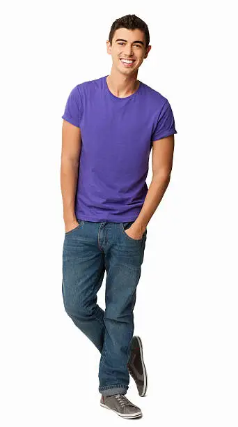 Full length portrait of young man in casual wear standing with hands in pockets. Vertical shot. Isolated on white.
