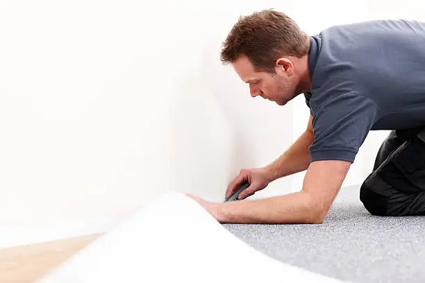 Photo of Installer using carpet knife to tuck new floor