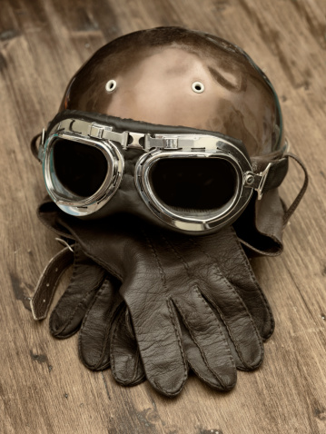 Old motorcycle helmet with glasses and gloves