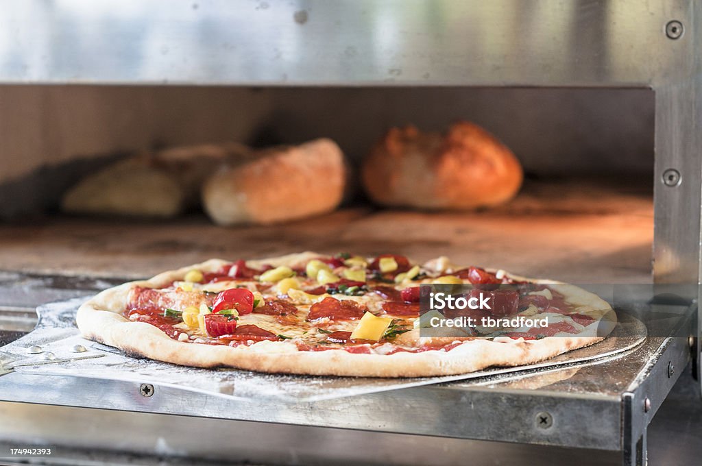 Pizze cottura In un forno a legna - Foto stock royalty-free di Alla griglia