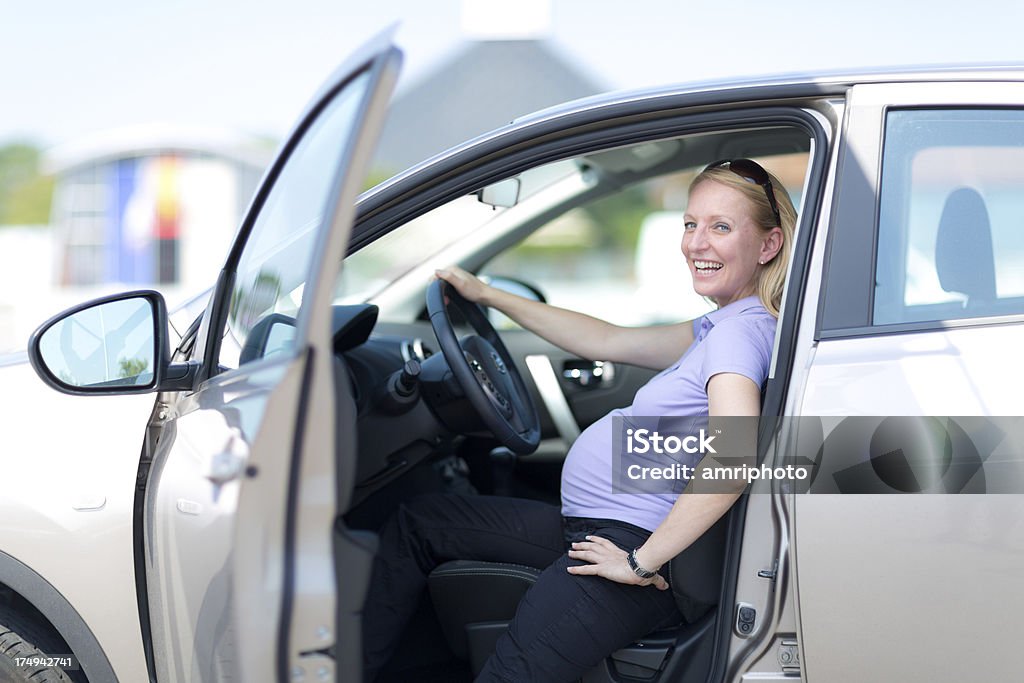 Heureuse Femme enceinte, assis dans la voiture - Photo de Voiture libre de droits