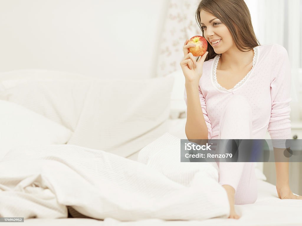 Belle femme mange une pomme en chemises de nuit - Photo de Adulte libre de droits