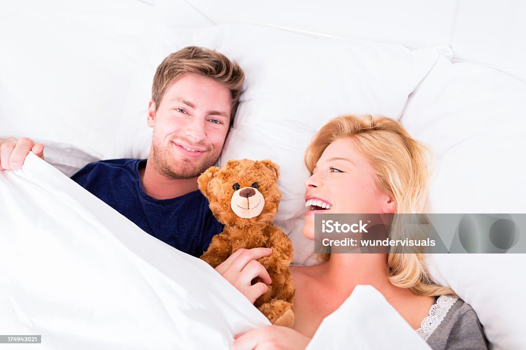 Junges Paar Kuscheln im Bett mit Teddybär - Lizenzfrei Paar - Partnerschaft Stock-Foto