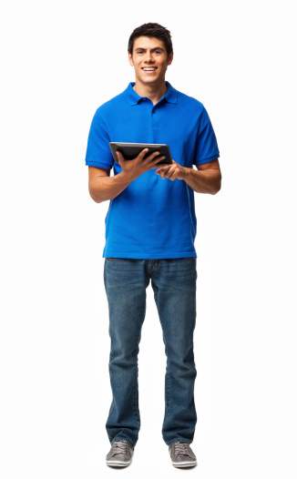 Full length portrait of young man in casual apparel using digital tablet. Vertical shot. Isolated on white.