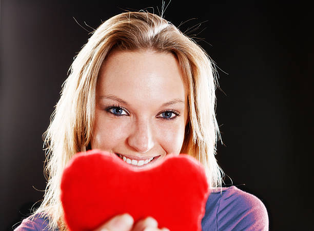 istock Smiling blonde beauty offers her heart 174943676