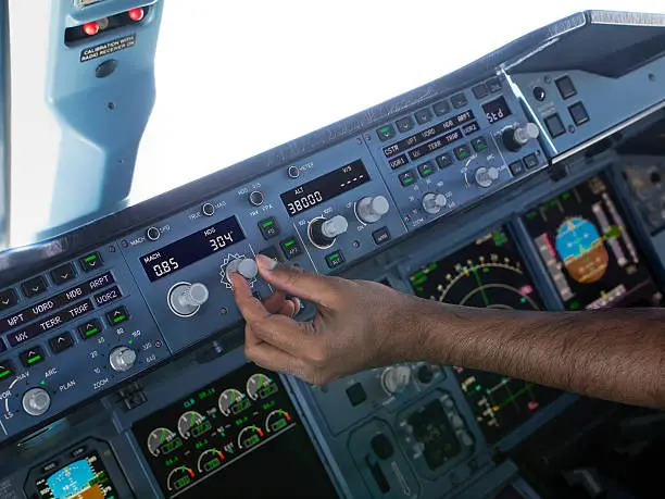 A pilot setting the 'Heading Selector' on the Flight Control Unit (FCU) of an Airbus 380 aeroplane in flight.