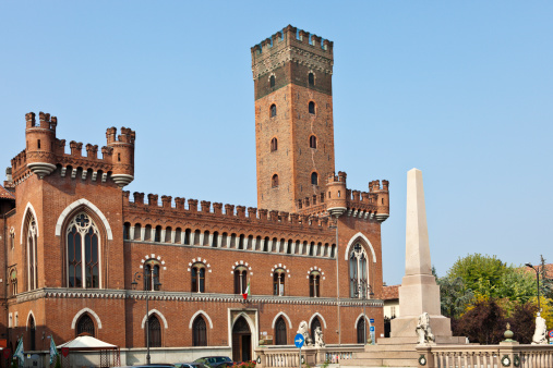 View across the Piazza Roma with its obelisk to the Palazzo Medici del Vascello and in the background the Torre Comentina in Asti, a city with a long history in Piedmont, Italy.