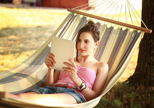 istock girl reading a tablet in hammock 174944542