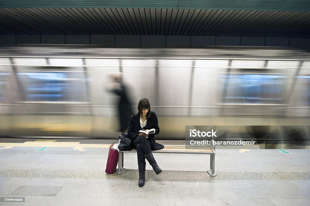 Jeune femme lisant un livre dans la station de métro - Photo de Adulte libre de droits