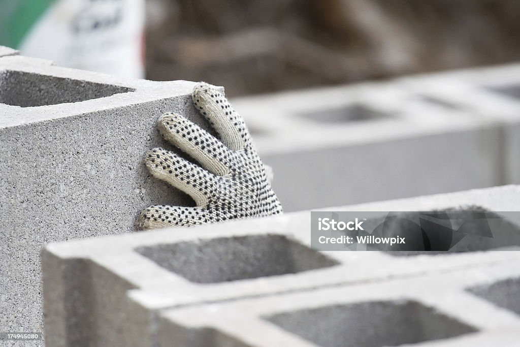 Rutschhemmendes Sicherheit Handschuh auf Hand Stapeln konkrete Häuserblocks - Lizenzfrei Beton Stock-Foto