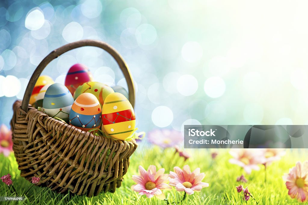 Coloridos huevos de Pascua en cesta en prado - Foto de stock de Huevo de Pascua libre de derechos