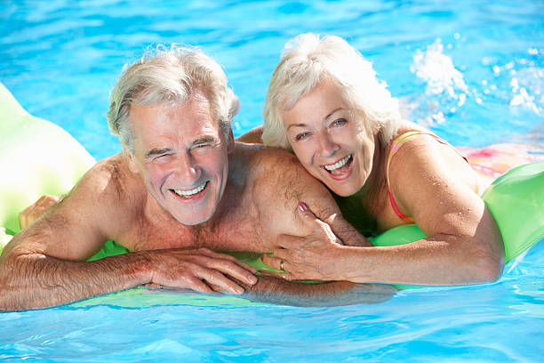 istock Senior Couple On Holiday In Swimming Pool 174946372