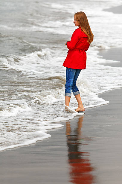 istock girl walking along the sea 174946496