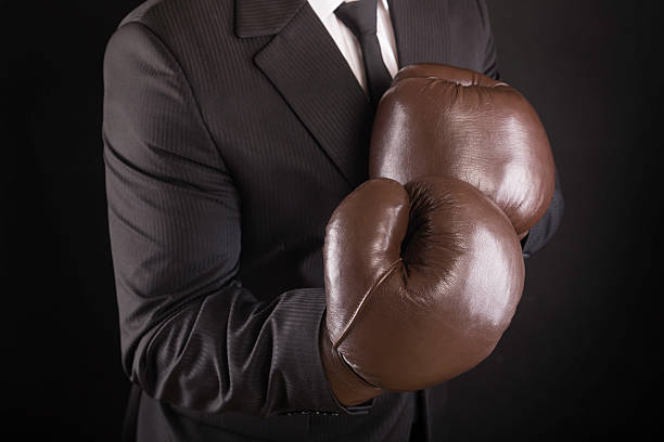 uomo d'affari con guantoni da boxe - conflict boxing glove classic sport foto e immagini stock