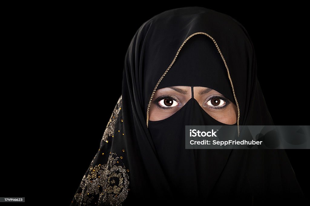 Eyes of an oriental muslime woman with veil Muslime woman with veil is looking to the camera. Close up of the eyes. Black background Adult Stock Photo
