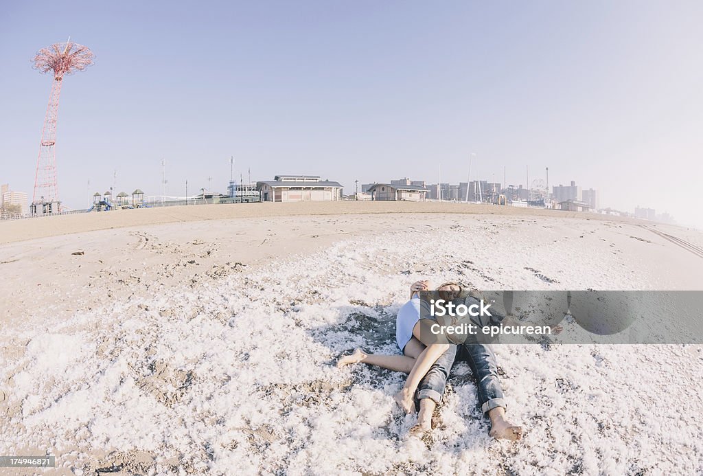Agotado novio y novia después de una lucha con almohada en la playa - Foto de stock de 20 a 29 años libre de derechos