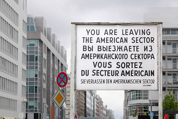 Checkpoint Charlie sign "Sign at Checkpoint Charlie in Berlin, where the wall used to divide the city." east berlin photos stock pictures, royalty-free photos & images