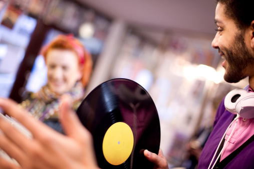 two young people chatting in a record shop .