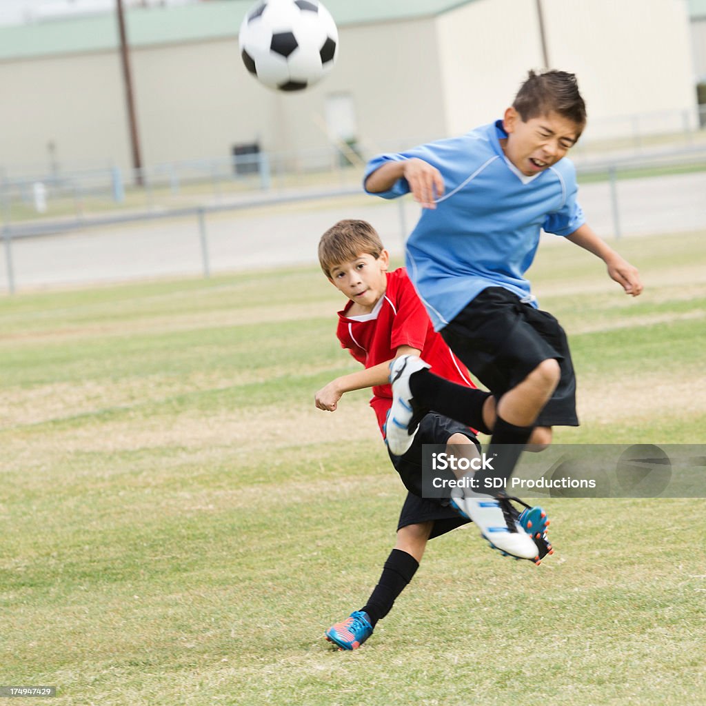 Les jeunes joueurs de football intenses au cours de jeu de frappe - Photo de 10-11 ans libre de droits