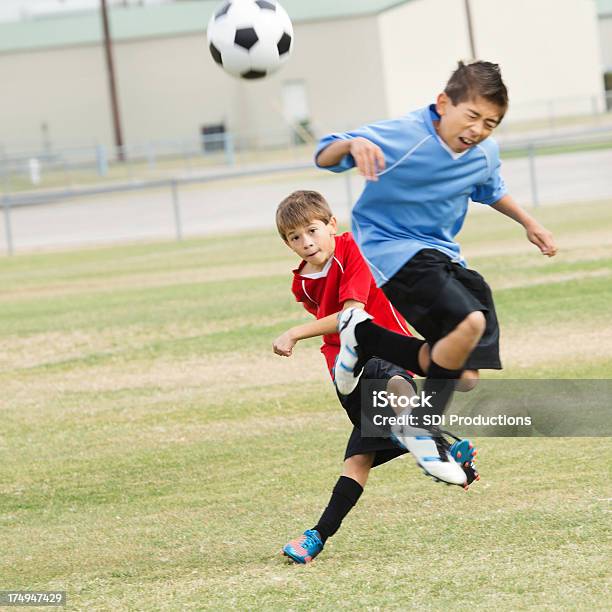 Photo libre de droit de Les Jeunes Joueurs De Football Intenses Au Cours De Jeu De Frappe banque d'images et plus d'images libres de droit de 10-11 ans