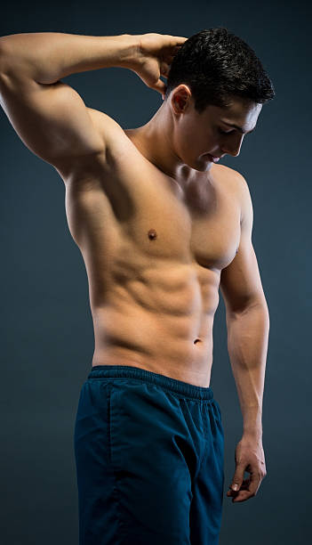 молодой musular человек над серый фон - sex symbol the human body male abdomen стоковые фото и изображения