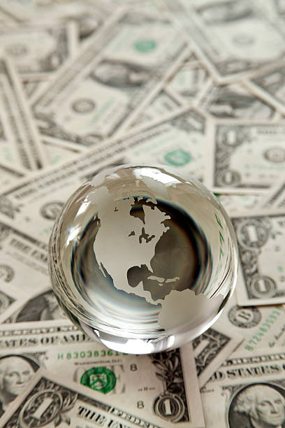 globo di vetro e banconote dollaro - global finance currency earth macro foto e immagini stock