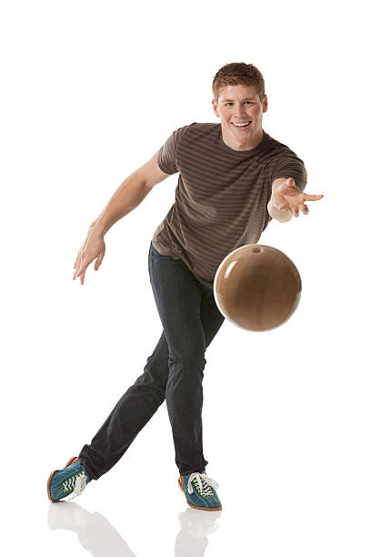 souriant jeune homme jouant avec une boule de bowling - bowling isolated sportsman vertical photos et images de collection