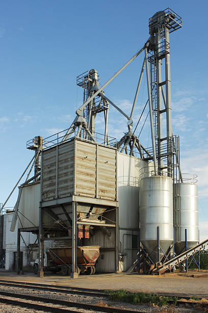 Grain Silo Truck Loading Station Granary facility showing grain delivery system.  Grain is moved from storage by elevators up the towers and down chutes into bins with large funnel chutes that dispense the commodity into waiting trucks.  This facility also has railcar loading capability. arkansas kansas stock pictures, royalty-free photos & images