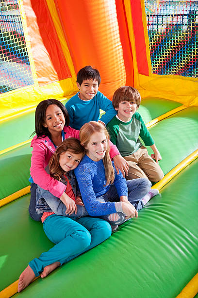 kinder in bounce house - house bouncing multi colored outdoors stock-fotos und bilder