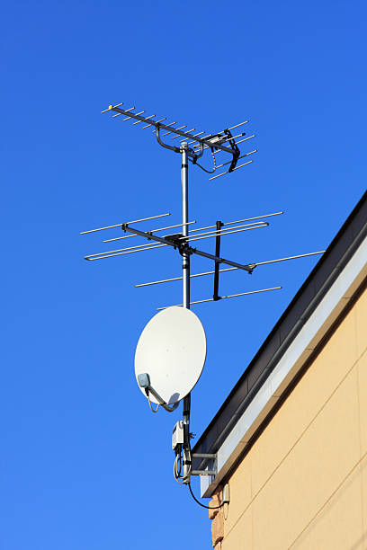 istock Satellite receiver dishes and TV antenna on blue sky 174948691