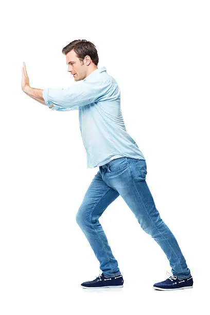 A casual young man pushing against something while isolated on a white background