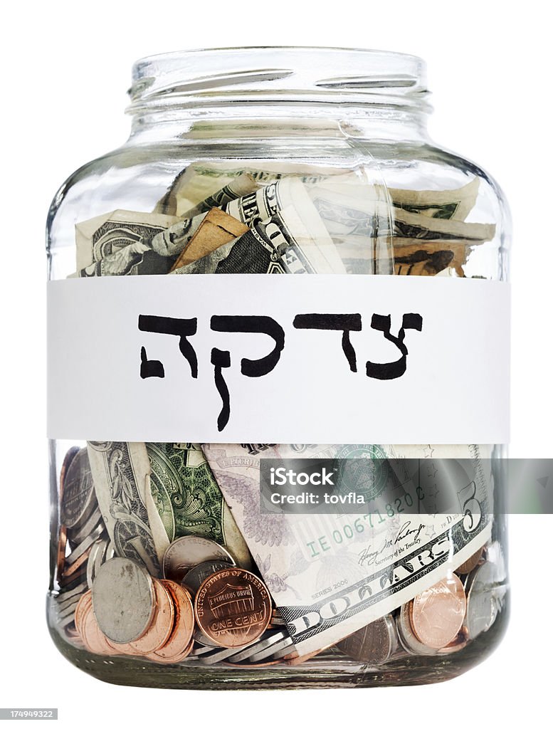 Charity Jar w/ Clipping Path Tzedakah (charity) written in hebrew on a jar filled with change. Clipping path included. American One Dollar Bill Stock Photo