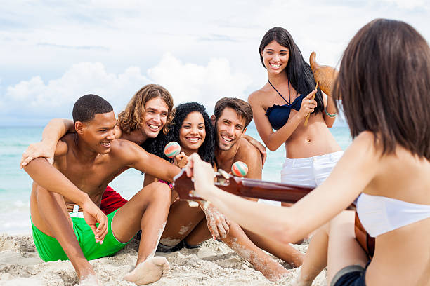 友と笑う喜びや歌のビーチ - multi ethnic group beach women maraca ストックフォトと画像