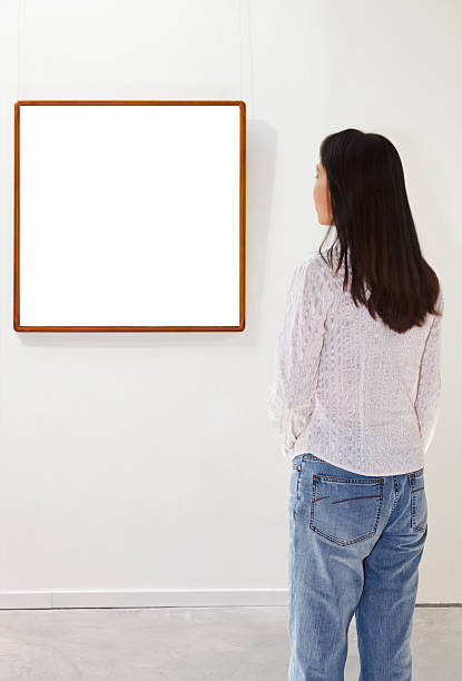 istock One woman looking at white frame in an art gallery 174950507
