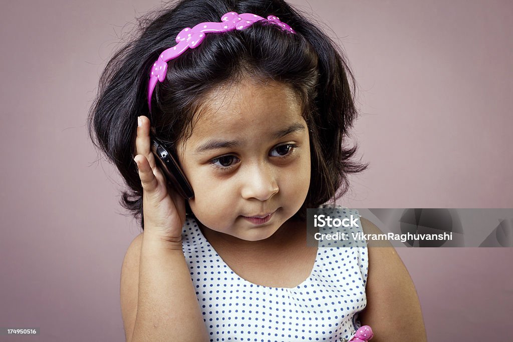 Cheerful Asian Indian Baby Girl Talking on the Phone Mobile Phone Stock Photo