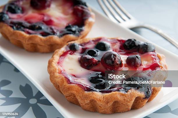 Two Blueberry Cranberry Tarts On A Flower Placemat Stock Photo - Download Image Now - Cranberry, Lemon - Fruit, Tart - Dessert