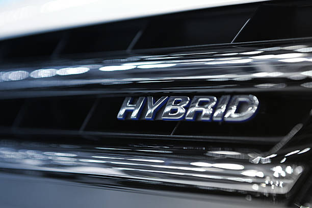 Hybrid Car Engine Hybrid Word Written on car grill filtered to chrome and blue cold colors..Car Related Images.. hybrid car photos stock pictures, royalty-free photos & images