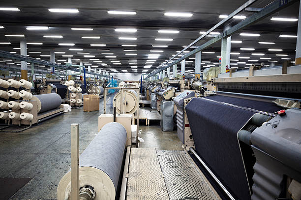 Denim Textile Industry - Weaving Jeans Fabric on Airjet Looms Weaving fabric on air jet looms in big textile weaving unit. loom photos stock pictures, royalty-free photos & images