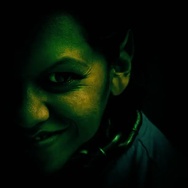 Evil green troll with a menacing smile.